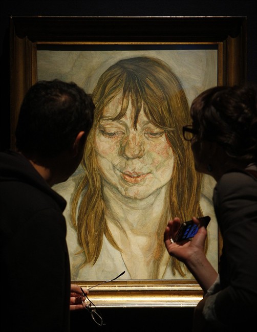 FILE In this June 24, 2011 photo, visitors look at Lucian Freud's work entitled 'Woman Smiling' during a photo call at Christie's in London, Friday, June 24, 2011. Lucian Freud, a towering and uncompromising figure in the art world for more than 50 years, had died after an illness, his New York-based art dealer said Thursday, July 21, 2011. He was 88. (AP Photo/Akira Suemori).