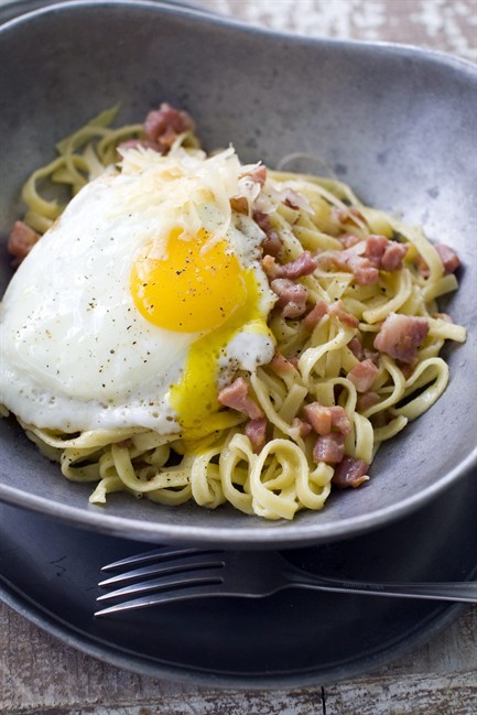 This June 6, 2011 photo shows whole egg pasta carbonara in Concord, N.H. Clocking in with just seven ingredients, this delicious take on pasta carbonara will have you in and out of the kitchen in under 20 minutes. It varies from traditional carbonara by not incorporating the egg into the cheese “sauce” with which the pasta is tossed. (AP Photo/Matthew Mea).
