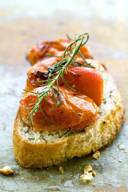This July 11, 2011 photo shows buttery roasted tomato bruschetta in Concord, N.H. This bruschetta recipe gets a pat of butter added at the end just before serving. (AP Photo/Matthew Mead).