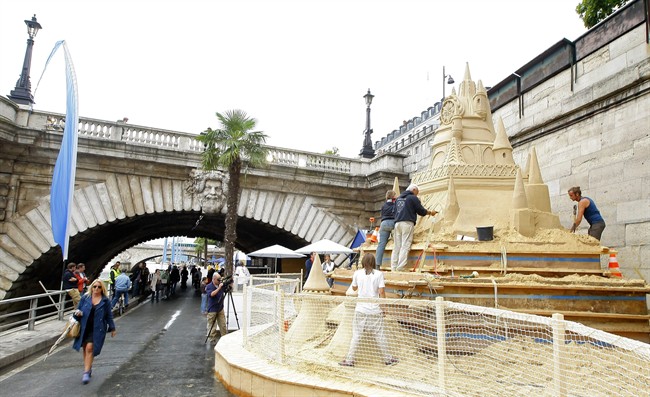 Sculptors prepare a sand sculpture of the Sleeping Beauty castle, as part of Paris Plage (Paris Beach) festivities, on the Seine river banks in Paris, Thursday, July 21, 2011. Paris Plage opens today to end on Aug.21 2011 and offers various summer activities in the French capital. (AP Photo/Jacques Brinon).