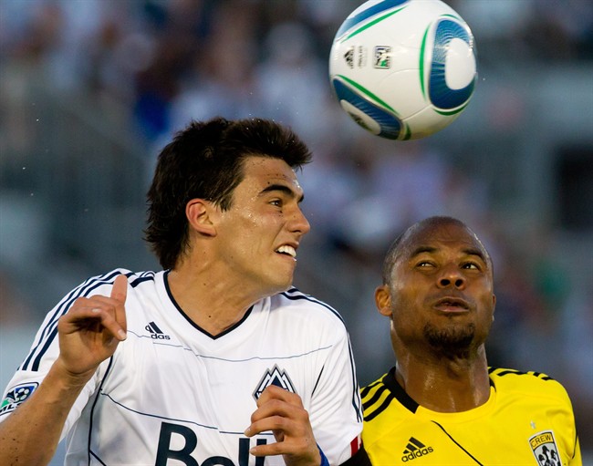 Vancouver Whitecaps' Omar Salgado, left, and Columbus Crew's Julius James battle for the ball during second half MLS soccer game action in Vancouver, B.C., on Wednesday July 6, 2011. THE CANADIAN PRESS/Darryl Dyck.