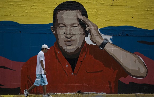 A man walks in front of a mural depicting Venezuela's President Hugo Chavez in Caracas, Venezuela, Saturday July 2, 2011. On Thursday evening Chavez announced in a televised speech that he underwent a second surgery in Cuba to remove a cancerous tumor. (AP Photo/Ariana Cubillos).