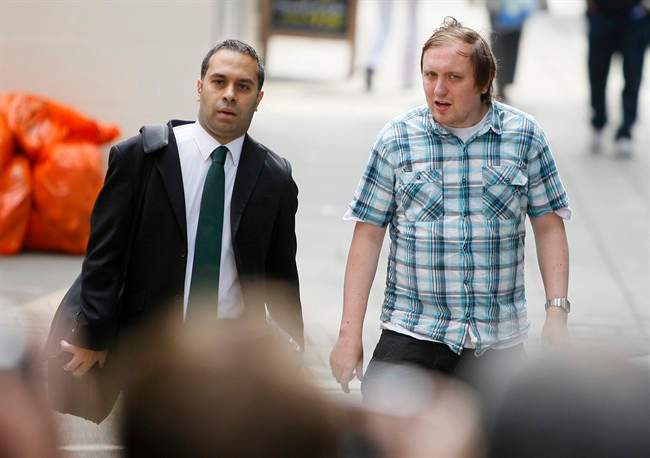 Jonathan May-Bowles, right, arrives at Westminster Magistrates Court to answer charges of a public order offence in London, Friday, July 29, 2011. My-Bowles has been accused of throwing a plate of shaving foam at media tycoon Rupert Murdoch as he gave evidence to a British Parliamentary select committee on July 20. Man at left is unidentified. (AP Photo/Alastair Grant).