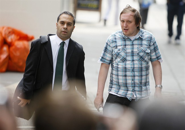 Jonathan May-Bowles, right, arrives at Westminster Magistrates Court to answer charges of a public order offence in London, Friday, July 29, 2011. My-Bowles has been accused of throwing a plate of shaving foam at media tycoon Rupert Murdoch as he gave evidence to a British Parliamentary select committee on July 20. Man at left is unidentified. (AP Photo/Alastair Grant).