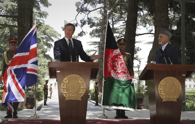 British Prime Minister David Cameron, left, speaks as he gestures to Afghan President Hamid Karzai during a joint press conference at the presidential palace in Kabul, Afghanistan on Tuesday, July 5, 2011. (AP Photo/Musadeq Sadeq).