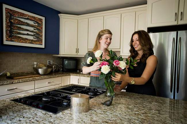 Wedding coordinator Jessica Kavanagh, right, arranges flowers with her client Alyson Mackenzie in Toronto on Wednesday, August 17, 2011. Decades of brides have walked down the aisle sporting something old, something new, something borrowed or something blue. Jessica Kavanagh's clients can also boast something black — the bottom line of their wedding day budget. THE CANADIAN PRESS/Aaron Vincent Elkaim.