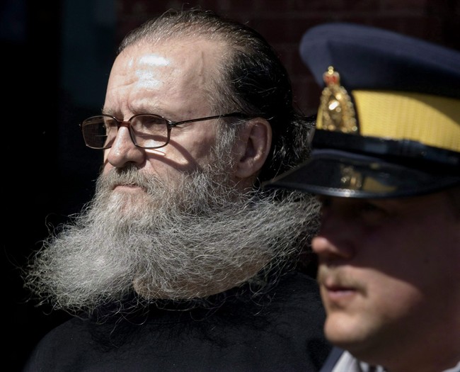 An RCMP officer escorts 62-year-old Romeo Jacques Cormier from court in Moncton, N.B. on March 25, 2010. The New Brunswick woman held captive by Cormier in a basement apartment for nearly a month where she was sexually assaulted says she feels her dignity has been taken away. T HE CANADIAN PRESS/Andrew Vaughan.