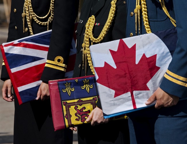 Navy, army and air force officers, left to right, hold flags of the three forces at a ceremony in Halifax on Tuesday, Aug. 16, 2011. Federal Defence Minister Peter MacKay announced that the services will officially be known as the Royal Canadian Navy and the Royal Canadian Air Force and the Canadian Army.