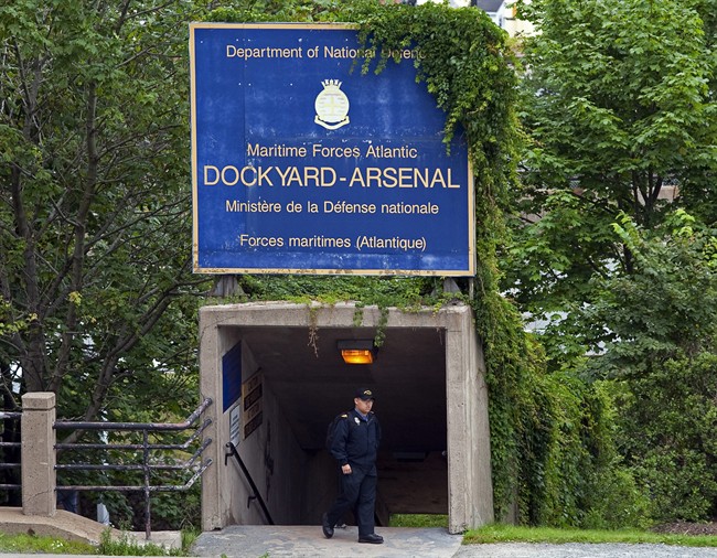 A sailor walks under signage at Maritime Forces Dockyard in Halifax on Monday, Aug. 15, 2011.