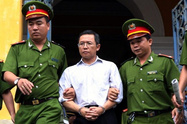 Police officers escort French-Vietnamese math professor Pham Minh Hoang out of a courthouse in Ho Chi Minh City, Vietnam, Wednesday, Aug. 10, 2011. Hoang was sentenced to three years in Vietnamese prison for belonging to a banned pro-democracy group and publishing an anti-communist blog online, his lawyer said. (AP Photo/Vietnam News Agency, Hoang Hai).