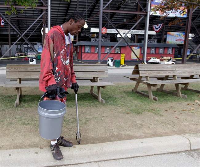 Roger Smith Jr. picks-up trash outside of the grandstand at the Indiana State Fair in Indianapolis, Sunday, Aug. 14, 2011. Five people were killed when a blast of wind toppled a stage and its rigging before a Sugarland concert at the Indiana State Fair. Smith was on of the people who rushed in to help those that were trapped. (AP Photo/Darron Cummings).