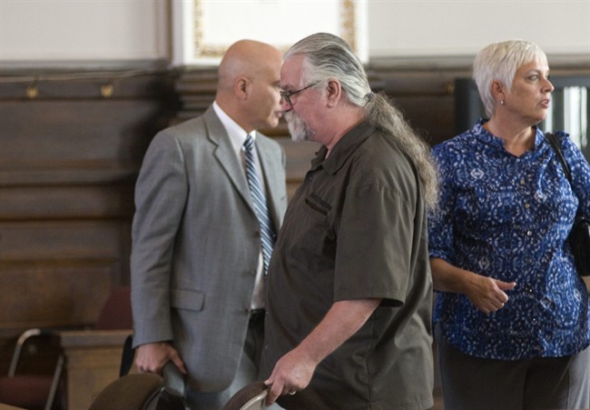 In this Aug. 18, 2011 photo, Phillip Seaton of Waddy, Ky., center, stands to leave court with his attorney Kevin George and wife Deborah after jury selection in their case against Dr. John Patterson, of Louisville, at the Shelby County Courthouse in Shelbyville, Ky. The dispute over the necessity of amputating Seaton's penis during surgery in 2008 is set to go to trial Monday, Aug. 22. (AP Photo/Brian Bohannon).