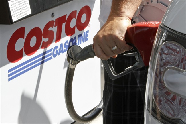 A person fuels his car at a Costco pump in Omaha, Neb., Tuesday, Aug. 9, 2011. Wholesale companies added to their stockpiles of autos, machinery and computers in June. Inventories rose for the 18th consecutive month and sales rebounded after a May decline.(AP Photo/Nati Harnik).