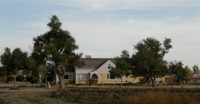 FILE - In this Oct. 19, 2009 file photo, the former home of the Herbert Clutter family is seen in Holcomb, Kan. Firefighters have put out a small fire in the rural southwest Kansas farmhouse where four family members were killed in 1959, sparking Truman Capote to write the critically acclaimed novel "In Cold Blood." Garden City Fire Chief Allen Shelton says the fire started Sunday night, Aug. 21, 2011, in an upstairs bedroom, most likely after a cigarette was left unattended. Firefighters were able to contain the blaze to a chair in the room, but the rest of the house sustained some smoke and water damage. (AP Photo/Charlie Riedel, File).