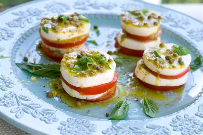 This Aug. 1, 2011 photo shows caprese salad with caper vinaigrette in Concord, N.H. To add a punch of tang to the salad, capers were added to the vinaigrette, as well as a sprinkled over the salad just before serving. (AP Photo/Matthew Mead).