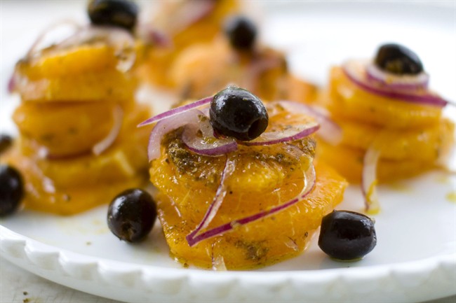 This photo shows an orange and red onion salad with warmed coriander oil.