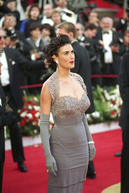 FILE- This March 30, 1992 file photo shows actress Demi Moore as she arrives at the 64th Annual Academy Awards in Los Angeles. As a young teenager, before the fame, kids, paparazzi and front-row seats at fashion shows, Moore regularly passed an Ann Taylor store at a local mall, taking note of the clothes. In the years since, she’s been a red-carpet rebel, jeans-wearing mom, bikini globetrotter and Versace model. Now things have come full circle, and Moore is the star of the Ann Taylor fall ad campaign. (AP Photo/Douglas Pizac, File).