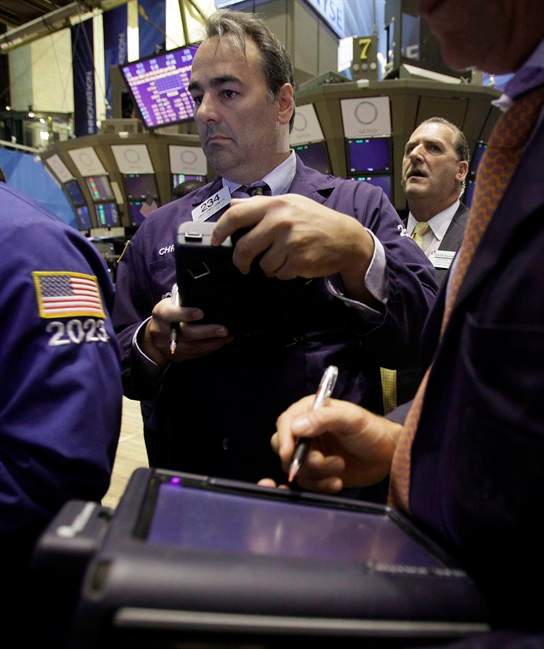 Trader Christopher Cornette, center, works on the floor of the New York Stock Exchange Thursday, Aug. 11, 2011. (AP Photo/Richard Drew).