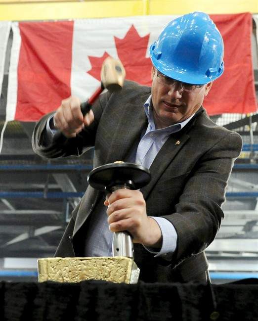 Prime Minister Stephen Harper stamps a $1.8-million bar of gold with a maple leaf as he tours Agnico-Eagle's Meadowbank mine facility in Meadowbank Mine, Nunavut on Wednesday, August 24, 2011. The mine is situated 75 kilometres north of the hamlet of Baker Lake. THE CANADIAN PRESS/Sean Kilpatrick.
