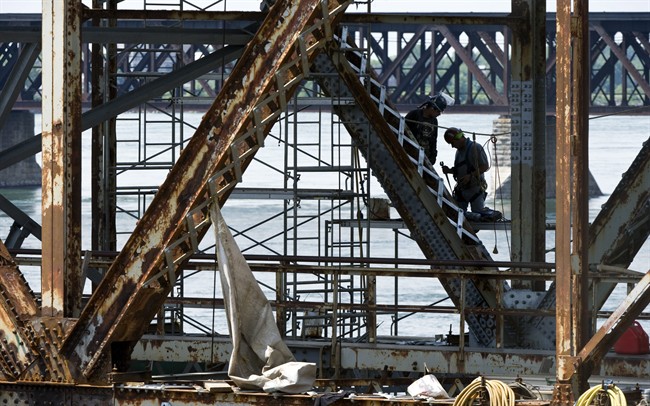Workers repair the Mercier bridge which spans across the St Lawrence River Wednesday, August 3, 2011 in Montreal.