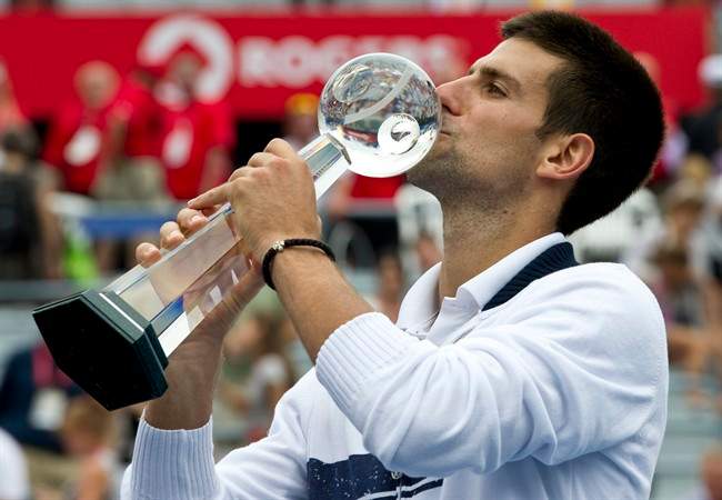 Novak Djokovic from Serbia kisses the trophy after beating Mardy Fish from the United States to win the men's final at the Rogers Cup tennis tournament Sunday, August 14, 2011 in Montreal. THE CANADIAN PRESS/Paul Chiasson.