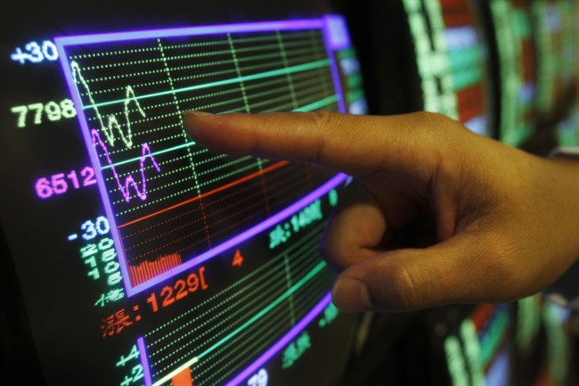 A securities manager points to a fluctuating stock indicator in Taipei, Taiwan, Wednesday, Aug. 17, 2011.