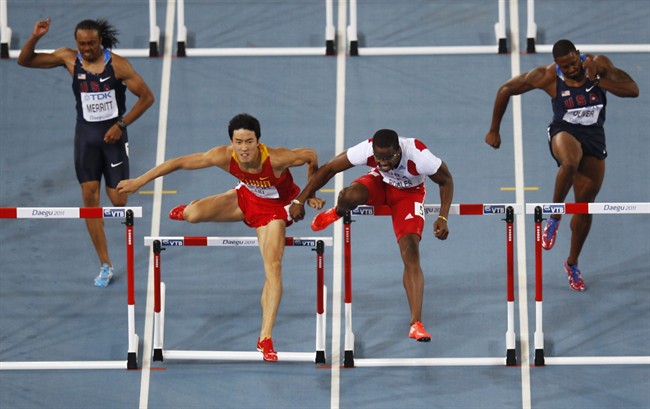 Cuba's Dayron Robles, center right, makes contact with China's Liu Xiang, center left, as USA's Aries Merritt, left, and USA's David Oliver, right, compete during the Men's 110m Hurdles final at the World Athletics Championships in Daegu, South Korea, Monday, Aug. 29, 2011. Robles finished first but was later disqualified for making contact with Liu. (AP Photo/Kevin Frayer).