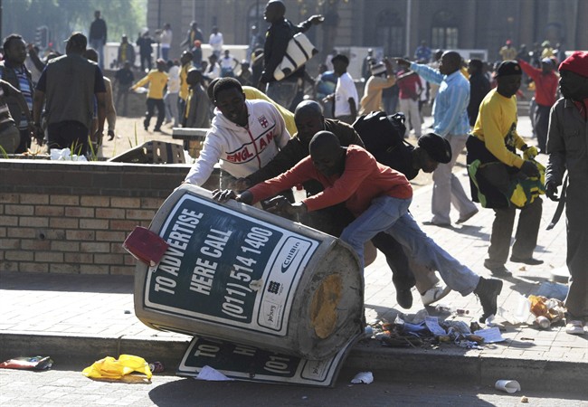 African National Congress Youth League (ANCYL) supporters overturn a trash bin in downtown Johannesburg, Tuesday, Aug. 30, 2011 as they protest at the start of a disciplinary hearing against their leader Julius Malema. Malema could be expelled or suspended from the ANC for bringing the party into disrepute with their calls for the overthrow of the governemnt of neighboring Botswana. (AP Photo).