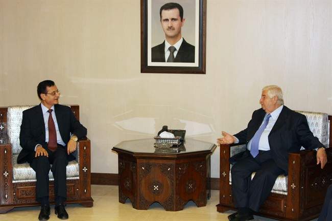 Syrian Foreign Minister Walid al-Moallem, right, meets with his Lebanese counterpart Adnan Mansour in Damascus, Syria, Sunday, Aug. 7, 2011. Mansour met earlier in the day with Syrian President Bashar Assad, who has stressed that his country is moving on steadily with the process of reforms and would simultaneously deal with outlaws to preserve the country's security. Portrait of Syrian President Bashar Assad at centre. (AP Photo/Bassem Tellawi).