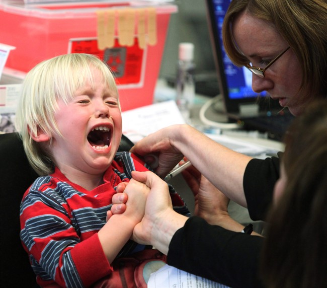 Four-and-a-half-year-old Mika Hoffer reacts as she is injected with the H1N1 flu vaccine at a clinic in Ottawa, Monday, October 26, 2009.