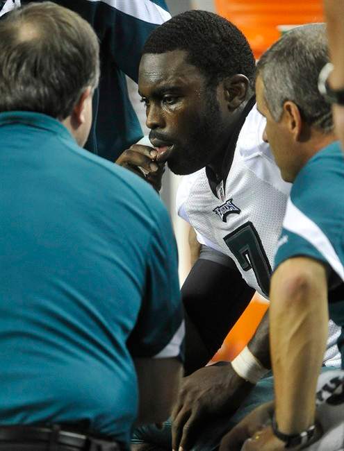Trainers talk with Philadelphia Eagles quarterback Michael Vick (7) after being injured in the second half of an NFL football game against the Atlanta Falcons at the Georgia Dome, Sunday, Sept. 18, 2011, in Atlanta. (AP Photo/John Amis).