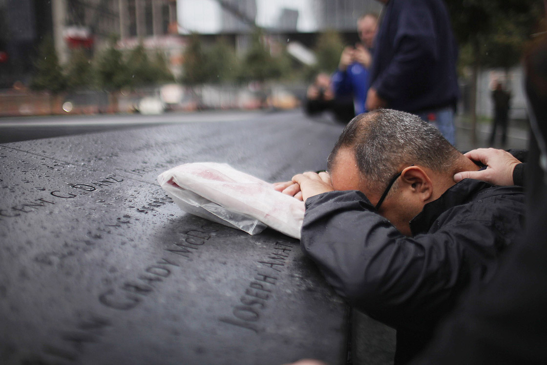 Eddie Reyes is comforted while remembering fifteen of his colleagues in the New York Police Department Emergency Service Unit who were killed on September 11, 2001 during a first responders wreath-laying ceremony at the National September 11 Memorial on September 20, 2011 in New York City. 