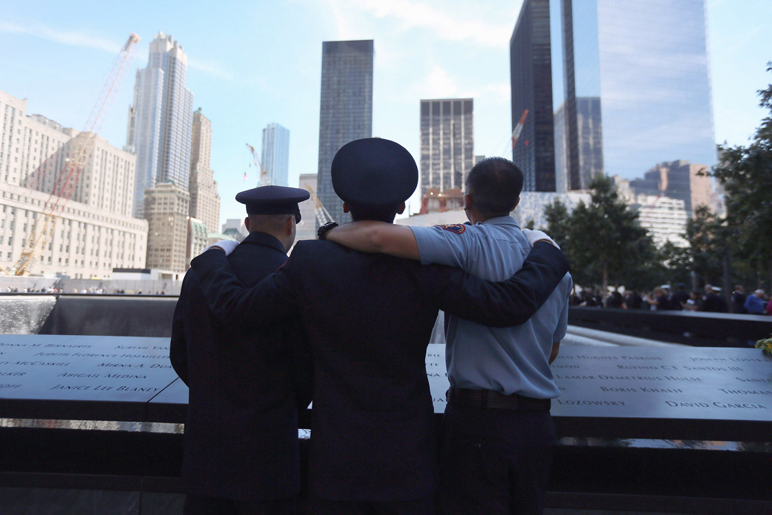 Firemen pay there respects at the 9/11 memorial during ceremonies for the eleventh anniversary of the terrorist attacks on lower Manhattan at the World Trade Center on September 11, 2012 in New York City.