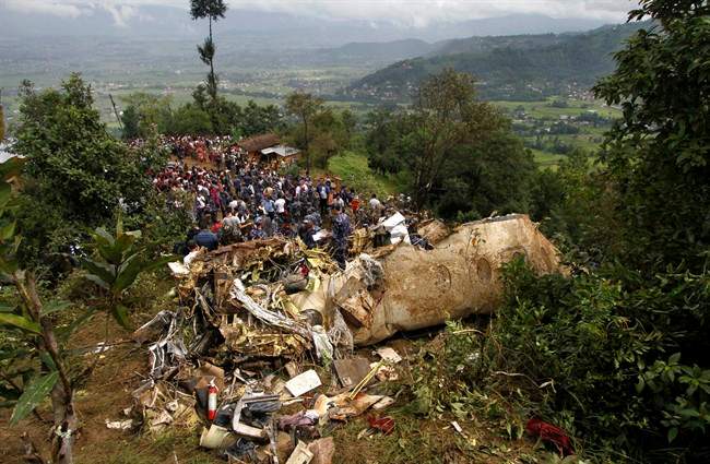 Nepalese rescue workers and civilians gather around the wreckage of a Beechcraft 1900D operated by Buddha Air after it crashed in the mountains outside Bisankunarayan village, just south of Katmandu, Nepal, early Sunday, Sept. 25, 2011. The plane carrying tourists to view Mount Everest crashed while attempting to land in dense fog on Sunday, killing all 19 people on board, officials said. (AP Photo/Niranjan Shrestha).