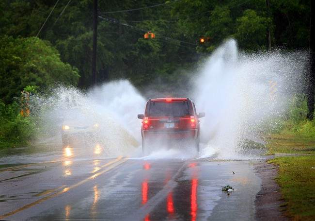 Vehicles drive through standing water on McVay Dr. in Mobile, Ala. on Saturday, Sept. 3, 2011. Tropical Storm Lee drenched the area with heavy rains. (AP Photo/Press-Register, Kate Mercer).
