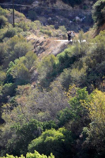 California Highway patrol officers investigate the scene of two cars that were recovered at the bottom of a remote mountain in Castaic, Calif., Friday, Sept. 30, 2011 .   David Lavau, whose car had plunged 200 feet off a remote mountain road, was found yesterday by his three adult children, who had enlisted the help of a missing persons detective. Lavau suffered multiple rib fractures, a broken arm and multiple fractures in his back. While he was being rescued, another vehicle was found nearby, its driver dead. Authorities don't know if that vehicle was involved in a collision with Lavau's car, or if it was a separate accident. (Photo/Gus Ruelas).