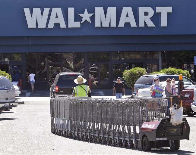 In this June 20, 2011 photo, a WalMart worker pulls carts at a WalMart store. (AP Photo/Paul Sakuma).