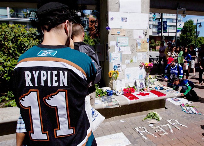 Tyler Stychyshyn wears a Manitoba Moose jersey as he pauses at a makeshift memorial for Rypien outside Rogers Arena in Vancouver, B.C., on August 17, 2011.