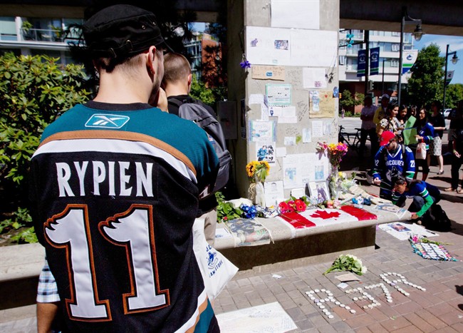 Tyler Stychyshyn wears a Manitoba Moose jersey as he pauses at a makeshift memorial for former Vancouver Canucks hockey player Rick Rypien outside Rogers Arena in Vancouver, B.C., on August 17, 2011. In the wake of the death of former NHL player Rick Rypien, the Vancouver Canucks plan to set up a charity fund to help educate people about issues surrounding mental health and depression. THE CANADIAN PRESS/Darryl Dyck.