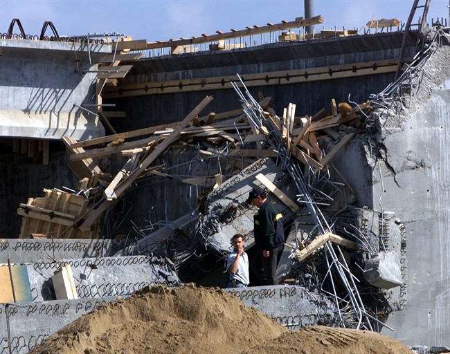 Investigators search through the rubble of a collapsed overpass in Laval, Que. in this June 19, 2000 photo. Two years of corruption scandals in Quebec have reached boiling point with the leak of a new study that reportedly describes an elaborate system of construction scams.The study from a newly created anti-corruption unit reportedly links the Mafia and criminal biker gangs to the construction industry, and the industry to political parties. THE CANADIAN PRESS/Ryan Remiorz.