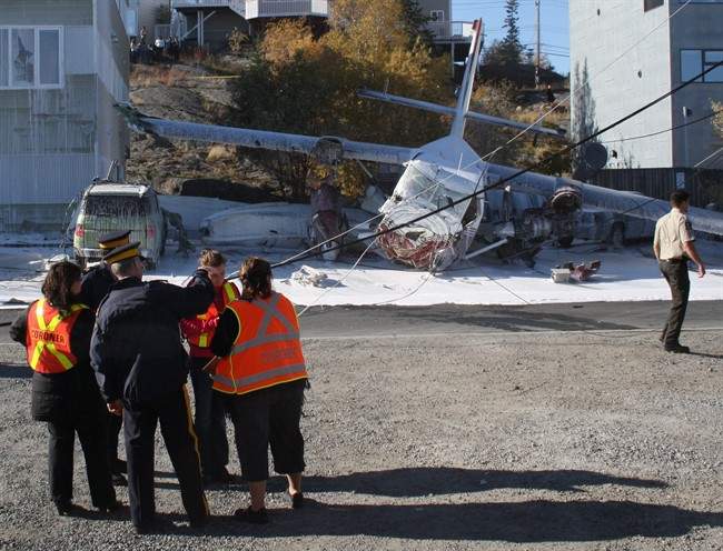 Emergency workers attend the scene of a plane crash in Yellowknife on Thursday Sept. 22, 2011. The plane, an Arctic Sunwest Charters Twin Otter which was equipped to land on water, went down after 1 p.m. in a part of town near Great Slave Lake. It crashed near the float plane docks, not far from the Bush Pilot's Monument. THE CANADIAN PRESS/John Doody.
