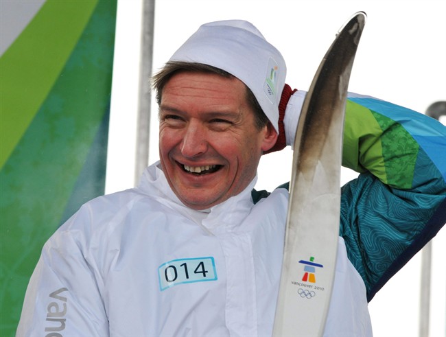 Former Olympian Alex Baumann adjusts his toque after carrying the Olympic Torch into Sudbury, Ont., on Saturday January 2, 2010. Concern for his family, a recent bout with cancer and a surprise job offer convinced Baumann to step down as chief executive officer of Own The Podium. THE CANADIAN PRESS/ Gino Donato.