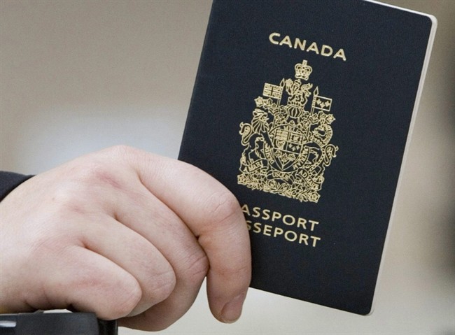A passenger holds his Canadian passport before boarding a flight in Ottawa. Hundreds of fake passports were seized by border agents in Canada last year.