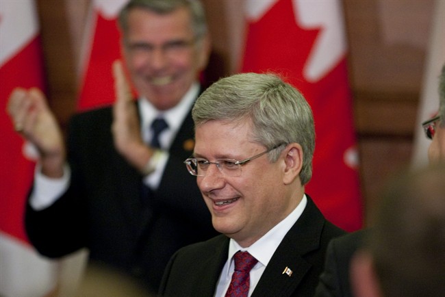 Prime Minister Stephen Harper smiles as he is applauded before the start of the Conservative caucus meeting on Parliament Hill, in Ottawa Thursday September 8 2011. THE CANADIAN PRESS/Fred Chartrand.