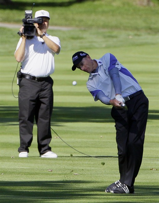 Jim Furyk, right, watches his approach shot on the ninth hole during the first round at the BMW Championship golf tournament on Thursday, Sept. 15, 2011, in Lemont, Ill. (AP Photo/Nam Y. Huh).