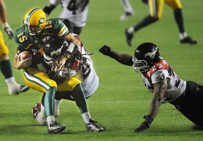 Calgary Stampeders' Kevin Dixon, right, sacks Edmonton Eskimos quarterback Ricky Ray during third quarter CFL football action in Edmonton, Alta., Friday, September 9, 2011. THE CANADIAN PRESS/John Ulan.