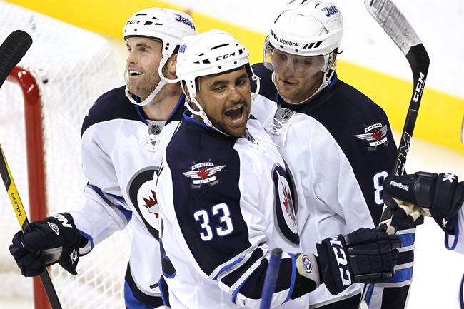 Winnipeg Jets Andrew Ladd (16), Dustin Byfuglien (33) and Nik Antropov (80) celebrate their 5th goal against the Columbus Blue Jackets during third period pre-season NHL action in Winnipeg on Tuesday, September 20, 2011. THE CANADIAN PRESS/John Woods.