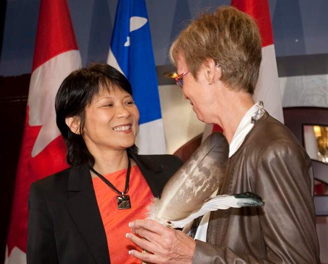 MP Olivia Chow, left, hands a pair of eagle feathers to NDP interim Leader Nycole Turmel Wednesday, September 14, 2011 at a pre-session caucus in Quebec City. Chow's late husband and former NDP Leader Jack Layton use to keep the feathers on his desk. THE CANADIAN PRESS/Jacques Boissinot.