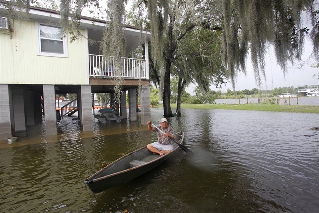 Ernie Adams paddles his pirogue past his neighbors house in floodwaters from Bayou Barataria, seen in background, in the aftermath of Tropical Storm Lee in the town of Jean Lafitte, La., just outside New Orleans, Saturday, Sept. 3, 2011. Bands of heavy rain and strong wind gusts from Tropical Storm Lee knocked out power to thousands in south Louisiana and Mississippi and prompted evacuations in bayou towns like Jean Lafitte. (AP Photo/Gerald Herbert).