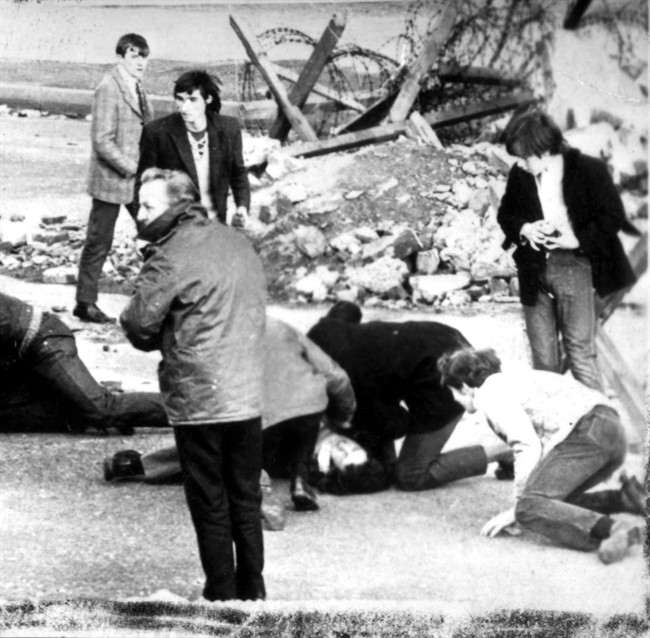 FILE - This is a Sunday Jan. 30, 1972 file photo of a man receiving attention during the shooting incident in Londonderry, Northern Ireland, which became known as Bloody Sunday. Britain's defense ministry says it is prepared to pay compensation to relatives of 13 Irish demonstrators shot to death in 1972 by British troops. The ministry said on Thursday Sept. 22. 2011 it was in contact with lawyers acting for the families of those killed during a protest in the Northern Ireland town of Londonderry, (AP Photo/PA, File) UNITED KINGDOM OUT NO SALES NO ARCHIVE.